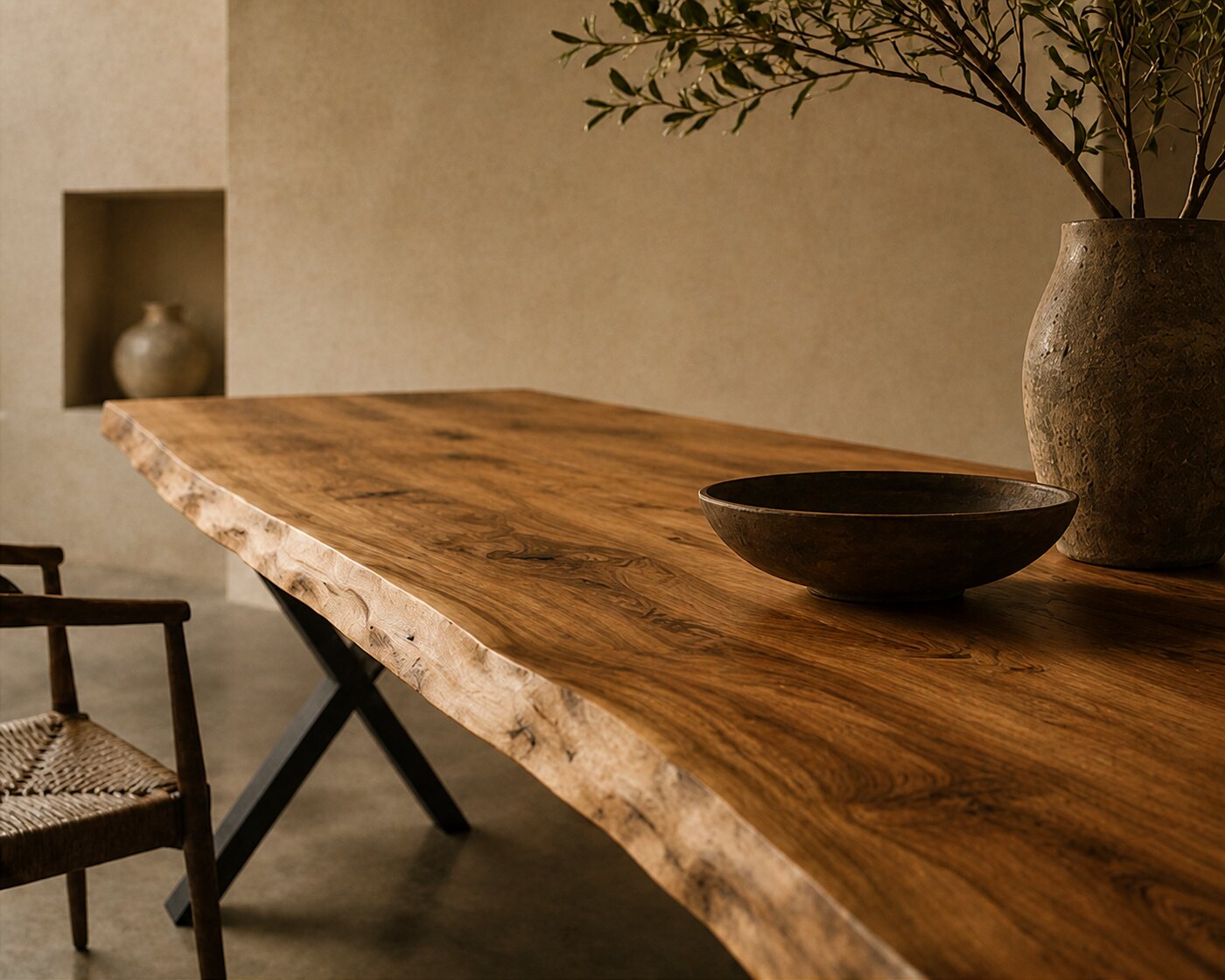 The live edge of a Suar slab wandering out of frame, its grain running the length of the table