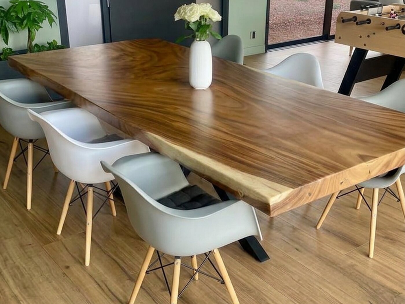 The table along its full length, sage wall behind and the drive through the glass